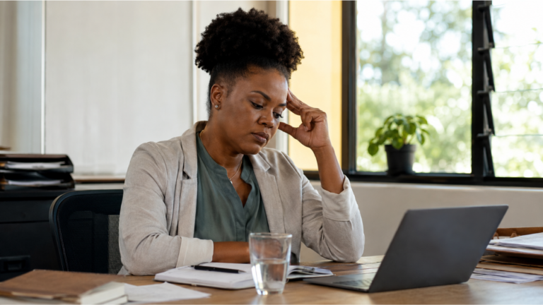 Caribbean woman pausing at her desk